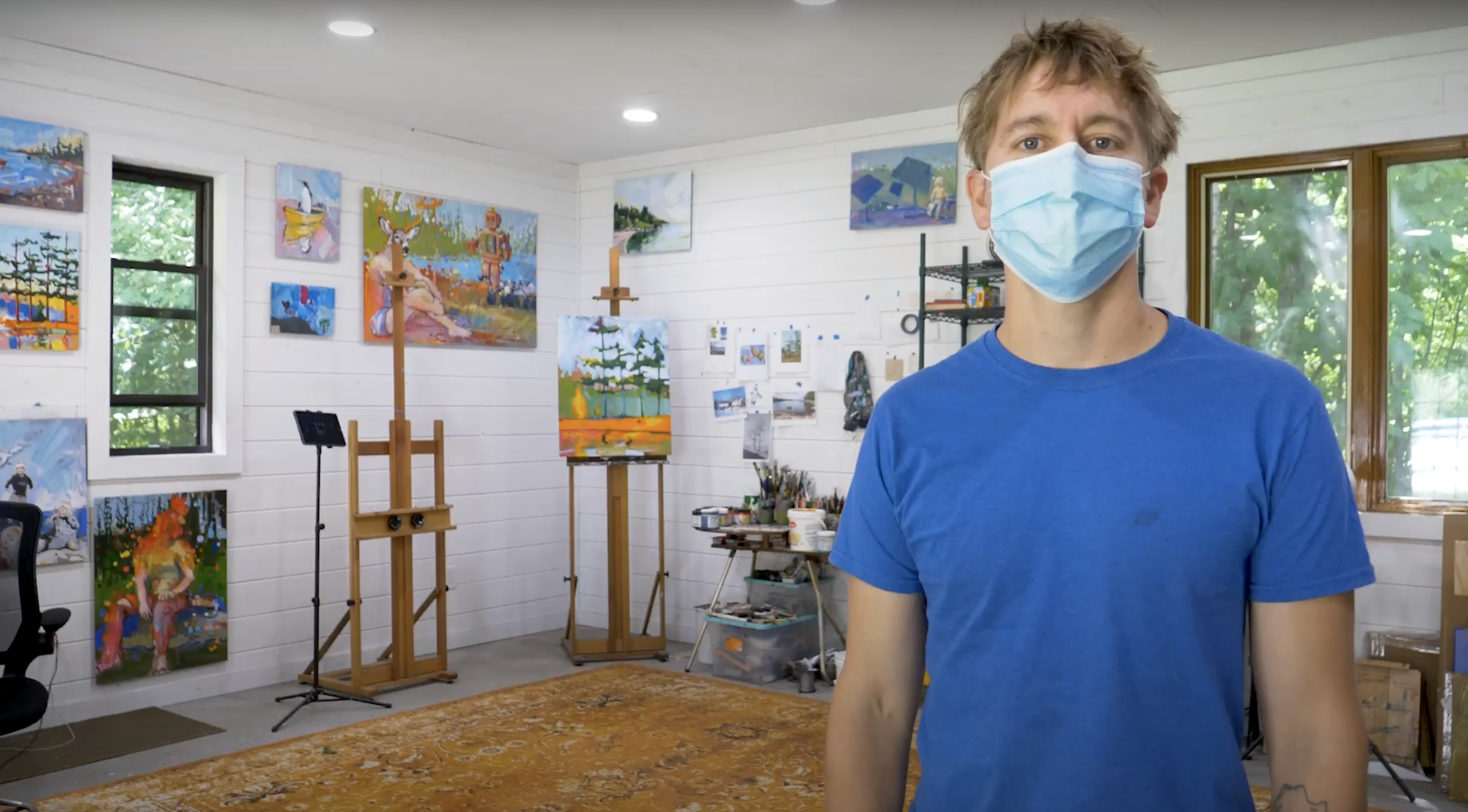 Photo of painter adam swanson in his studio with the artist looking at the camera